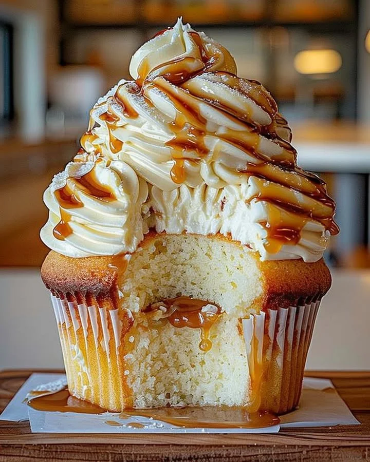 Delicious caramel cupcake with cream cheese frosting on a rustic wooden table