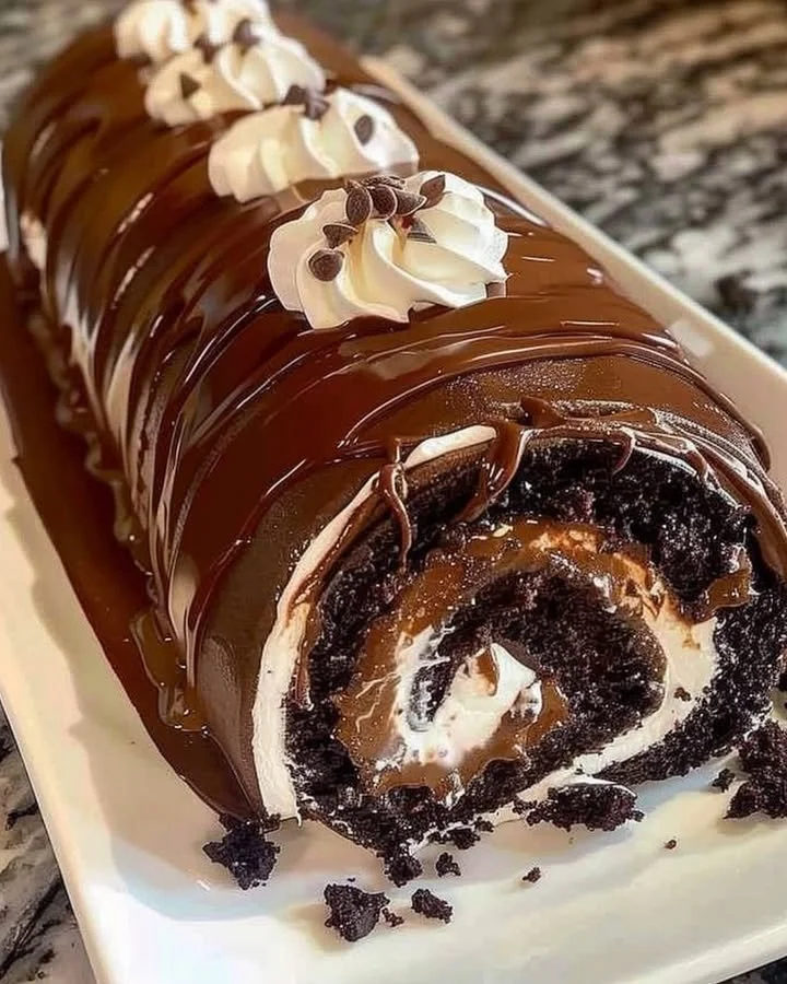 Delicious chocolate cake roll with whipped cream filling and chocolate ganache.