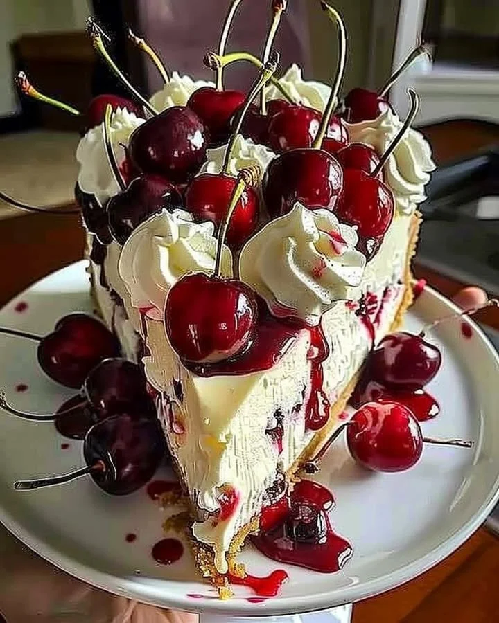Slice of elegant cherry cheesecake topped with fresh cherries and cream