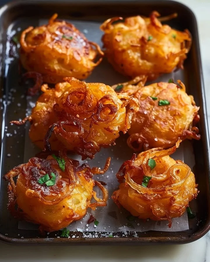 Delicious golden onion fritters served on a white plate