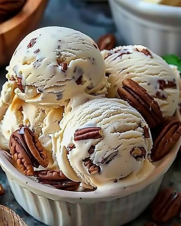 Homemade butter pecan ice cream in a bowl with pecans on top