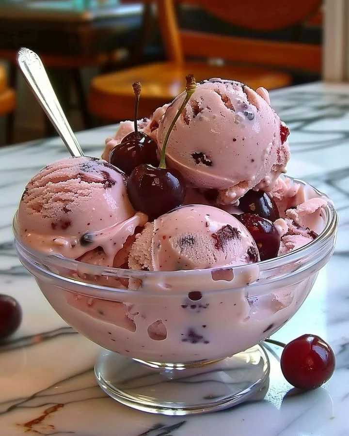 Creamy homemade cherry ice cream in a bowl with fresh cherries