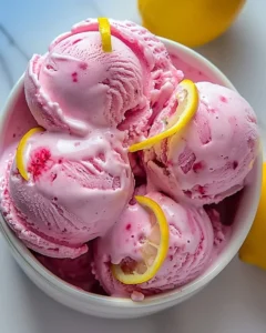 Delicious pink lemonade ice cream in a bowl with colorful sprinkles