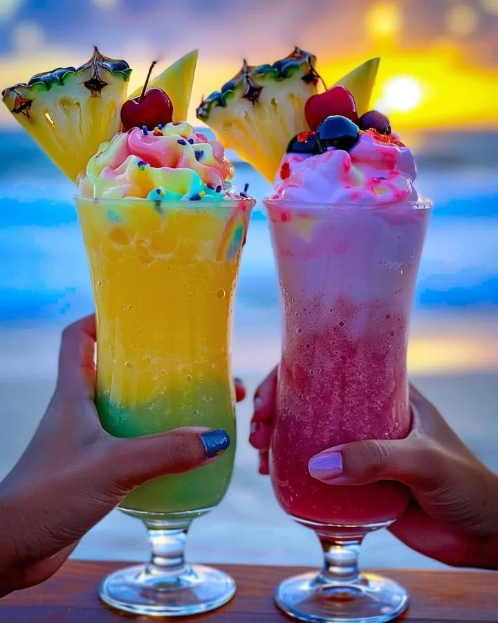 Colorful Rainbow Sherbet Piña Colada served in a glass with tropical garnishes