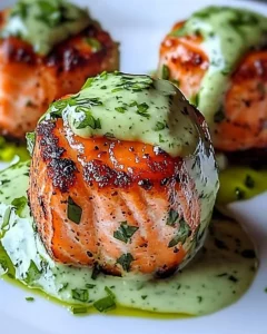 Delicious salmon balls served with creamy avocado sauce on a plate.